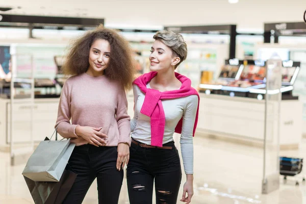 Twee beste vrienden collega meisjes poseren bij moderne winkelcentrum achtergrond — Stockfoto