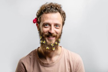 Tatmin olmuş yakışıklı adam beyaz arka planda izole edilmiş kameraya gülümsüyor..
