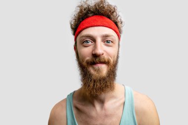 Handsome smiling young man in headband beard of flowers. clipart