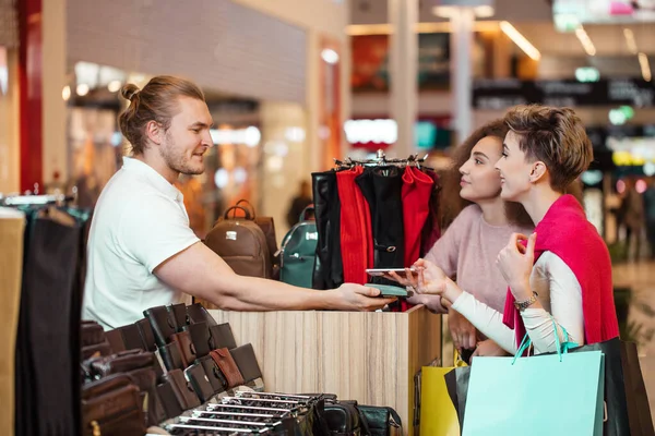 Női ügyfelek fizetése érintésmentes hitelkártyával NFC technológiával a boltban. — Stock Fotó