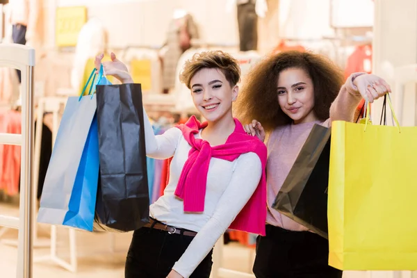 Two women with paper bags in the shopping mall. Sale, Consumerism Concept.