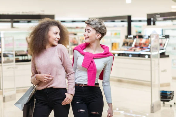 Twee vrouwen met papieren tassen in het winkelcentrum. Verkoop, Consumentisme Concept. — Stockfoto