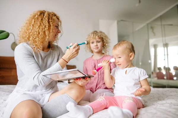 Mutlu kızıl anne ve küçük çocukları fırçalarla oynuyorlar. — Stok fotoğraf