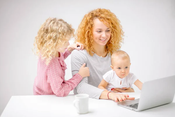 Mulher ruiva alegre e seus filhos assistindo fotos — Fotografia de Stock