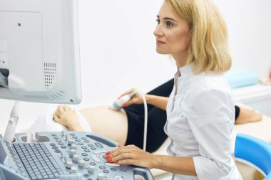 Çekici doktor ultrasonda bebeğin iç organlarına bakıyor.