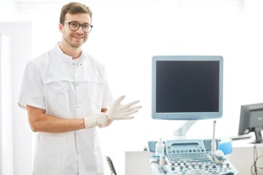 Pozitif cerrah ameliyattan önce eldiven giyiyor.