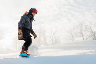 Adam arkadaşlarına snowboard 'lu bir atölye gösteriyor.