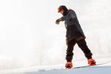 Harika adam snowboard yaparken dengesini korumaya çalışıyor.