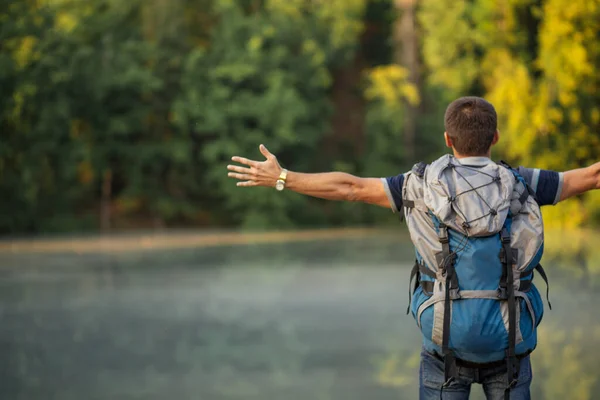 Молодий мотивований чоловік з розтягнутими руками дивиться на чудові пейзажі — стокове фото