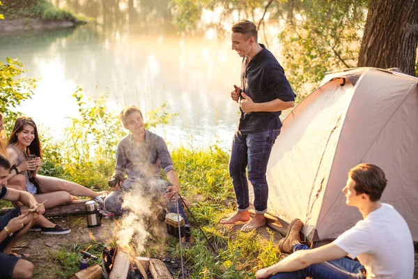 Beau touriste divertissant ses amis en camping — Photo