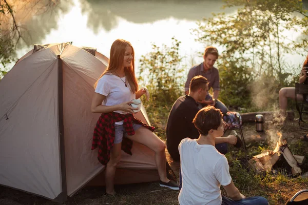 Zenzero bella ragazza è in piedi di fronte alla tenda e tenendo una tazza di tè — Foto Stock