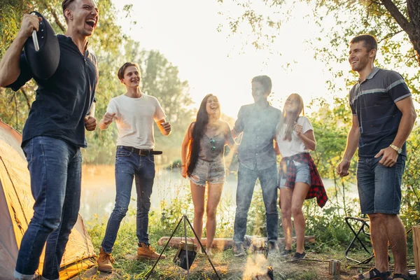 Hipster con risate isteriche in piedi intorno al falò — Foto Stock