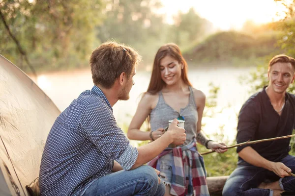 Foto vista posteriore. giovane uomo che beve acqua davanti agli amici — Foto Stock