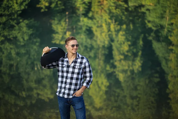 Tourist musician in sunglasses putting his hand on the pocket — Stock Photo, Image