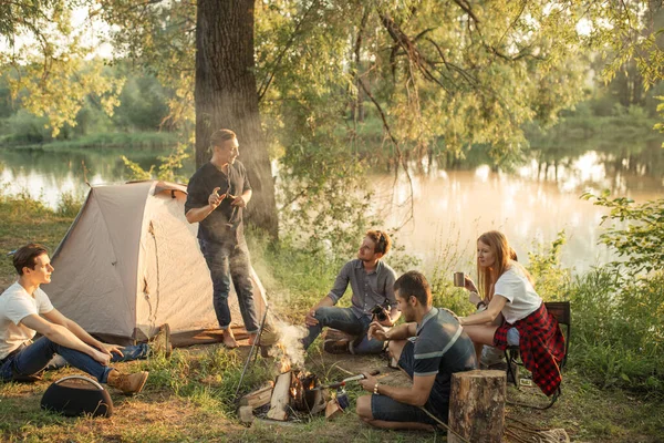 Colleagues are gathered around the bonfire and resting after hard week — Stock Photo, Image
