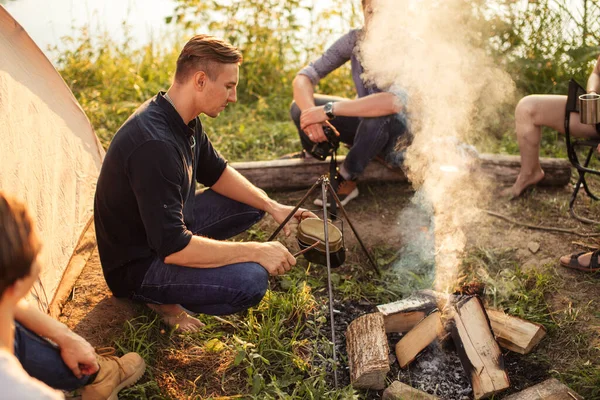 Attractive tourist is going to put the kettle on the bonfire — Stock Photo, Image