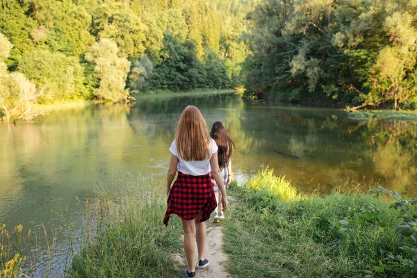 Dvě mladé ženy jdou k jezeru plavat — Stock fotografie