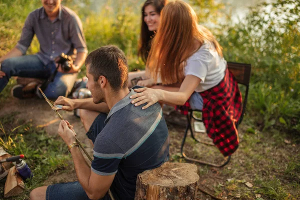 Attractive guy is cutting tree brunch for fishing . — Stock Photo, Image