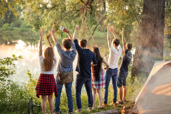 Um grupo de amigos agradáveis estão cumprimentando o nascer do sol — Fotografia de Stock