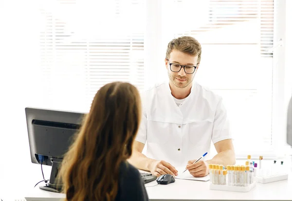 Hansome hälso specialist ger råd till en ung kvinna om graviditet — Stockfoto