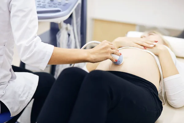 超音波装置で胃の中の赤ん坊を探している女性は — ストック写真