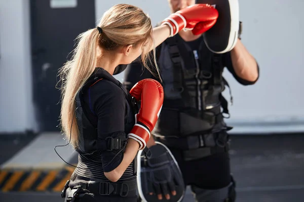 Sporty girl is working out with boxing gloves — Stock Photo, Image