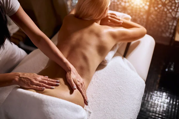 Handen masseren rug van jonge vrouw — Stockfoto