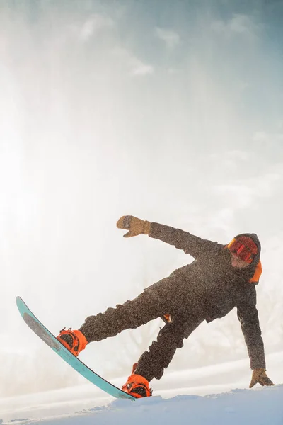 Snowboarder ativo está pulando com snowboard — Fotografia de Stock