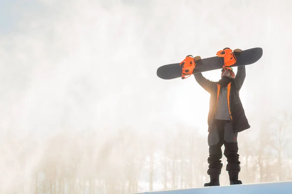 Ciddi bir snowboardcu inmeden önce snowboard 'unu kontrol ediyor. — Stok fotoğraf