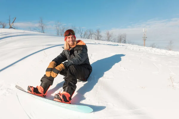 Desportista feliz está descansando na neve — Fotografia de Stock