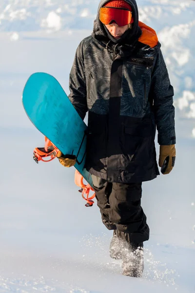 Angenehmer Mann fährt Snowboard auf einem felsigen Berg — Stockfoto