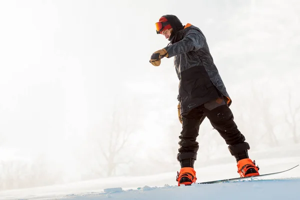 Homem incrível está tentando manter o equilíbrio durante snowboard — Fotografia de Stock