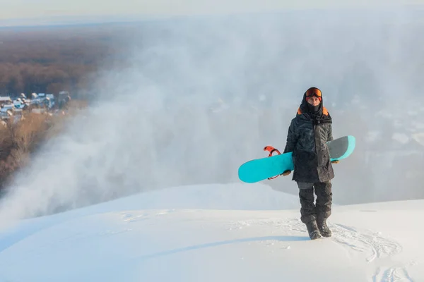 Homem snowboarder segurando uma prancha atrás de suas costas — Fotografia de Stock