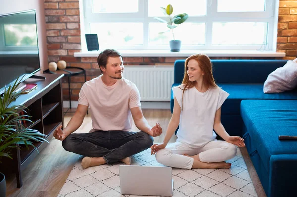 adorable couple meditating at home