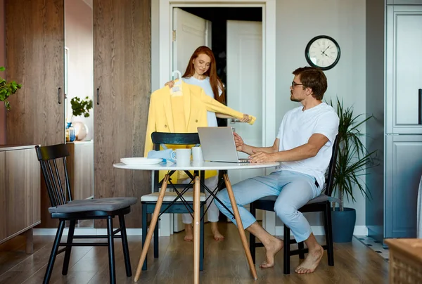 Frau fragt ihren Mann um Rat, während er arbeitet — Stockfoto