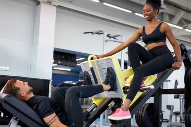 Spor salonundaki egzersizin doğruluğunu takip eden antrenör