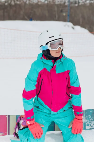 Kvinna med snowboard mask och träningsoverall vilar med snowboard — Stockfoto