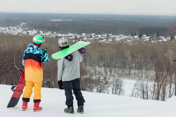 Jóvenes y elegantes hombres con tablas de snowboard descansando en la cima de la montaña —  Fotos de Stock