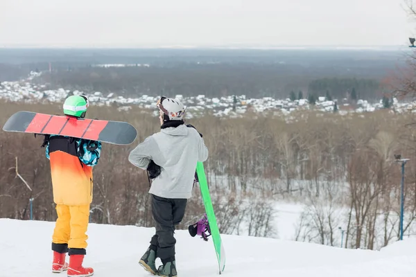 Vermoeide sporters met een pauze na het snowboarden — Stockfoto