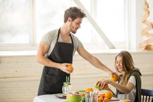 Impresionante hombre dando consejos a una chica mientras cocina en la cocina — Foto de Stock