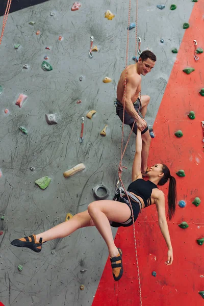 Cara bonito jogando uma piada em sua namorada enquanto escalava — Fotografia de Stock