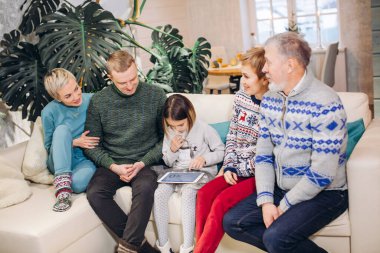 Akrabaları onu izlerken tatlı kız bilgisayar oyunları oynuyor.