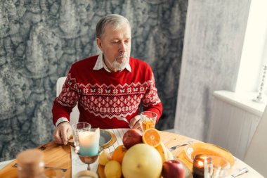 Mutfakta yemek yiyen zeki, sakallı bir adam.