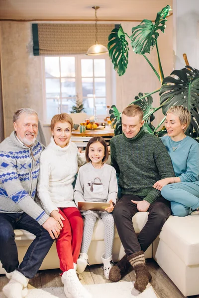 Glimlachen prachtige familie zitten op de bank met een laptop — Stockfoto