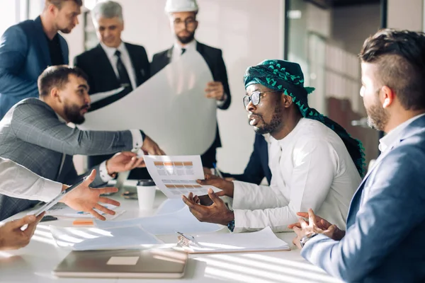 Grupo multirracial de constructores y arquitectos discutiendo el proyecto en la oficina. —  Fotos de Stock