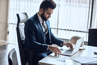 Bilgisayarla çalışan zarif bir iş adamı..