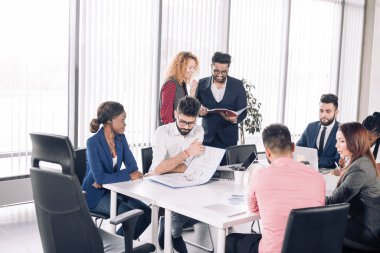 Bir grup farklı ırktan iş arkadaşı ofiste yeni bir projeyi tartışıyor..