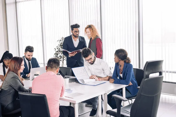 Grupo de compañeros de trabajo de raza mixta discutiendo nuevo proyecto en la oficina. — Foto de Stock