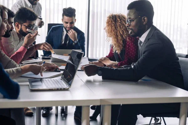 Handsome Chief Executive im Gespräch mit indischen männlichen Assistenten während eines Treffens — Stockfoto