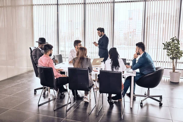 Jefe indio haciendo una llamada mientras sus colegas lo esperan — Foto de Stock